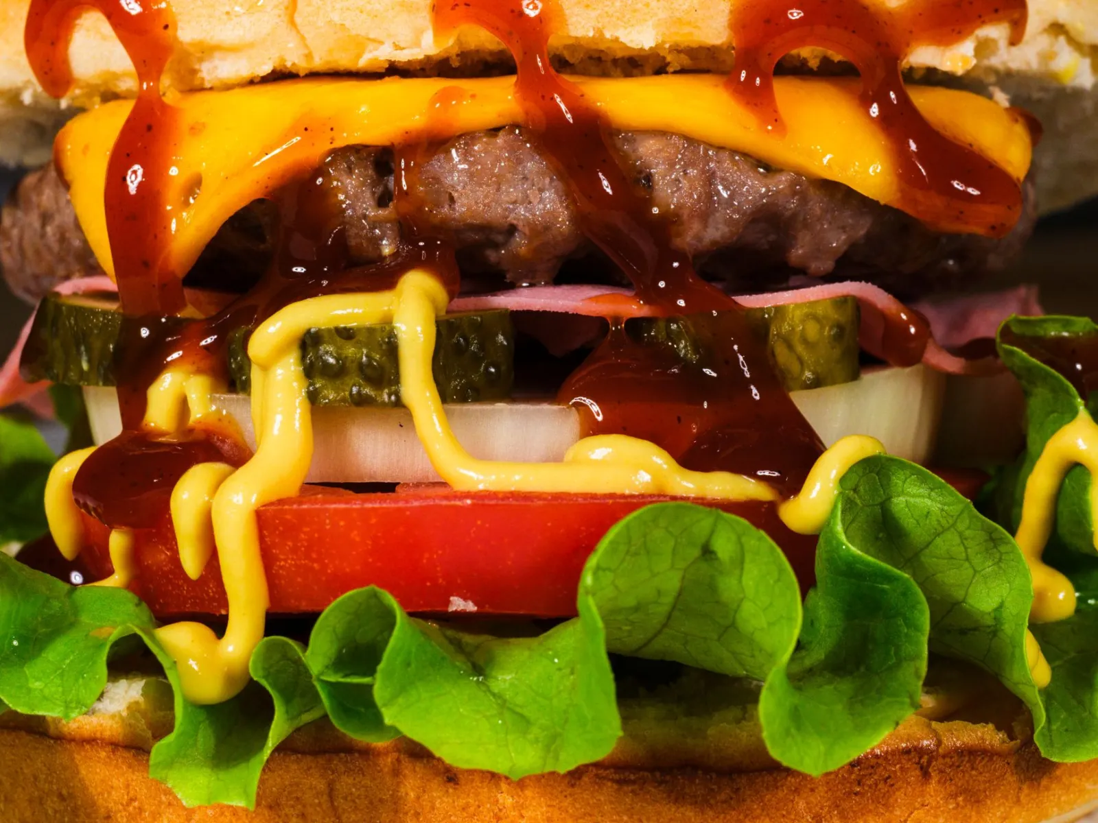 Mouth-watering close-up of a cheeseburger with toppings, showcasing textures and rich flavors.